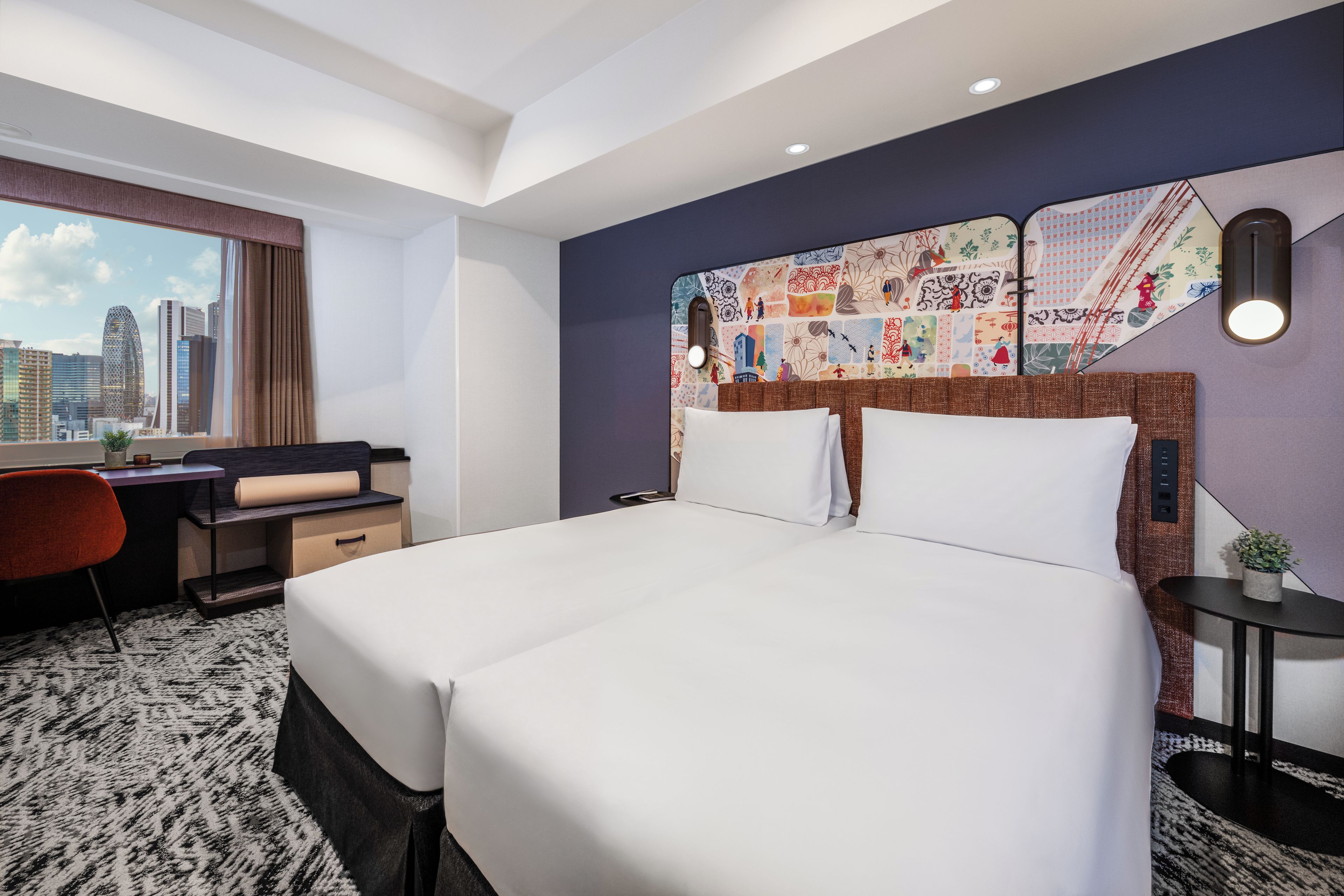 A hotel room with a large bed, a desk, and a view of the city skyline.