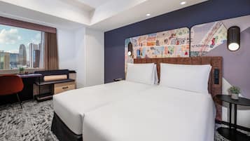 A hotel room with a large bed, a desk, and a view of the city skyline.