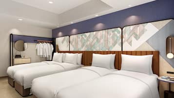A hotel room with two beds, a mirror, a dresser, and a wall with a geometric pattern.