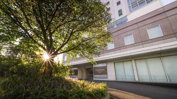 En bygning med et skilt der viser 'citadines North Shinjuku Tokyo' og et træ i forgrunden.
