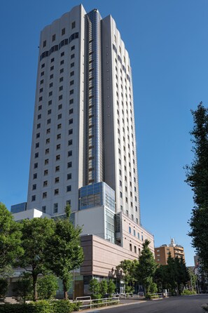 A tall, modern hotel building with a curved glass facade and multiple windows. - Citadines North Shinjuku Tokyo (Tokyo)