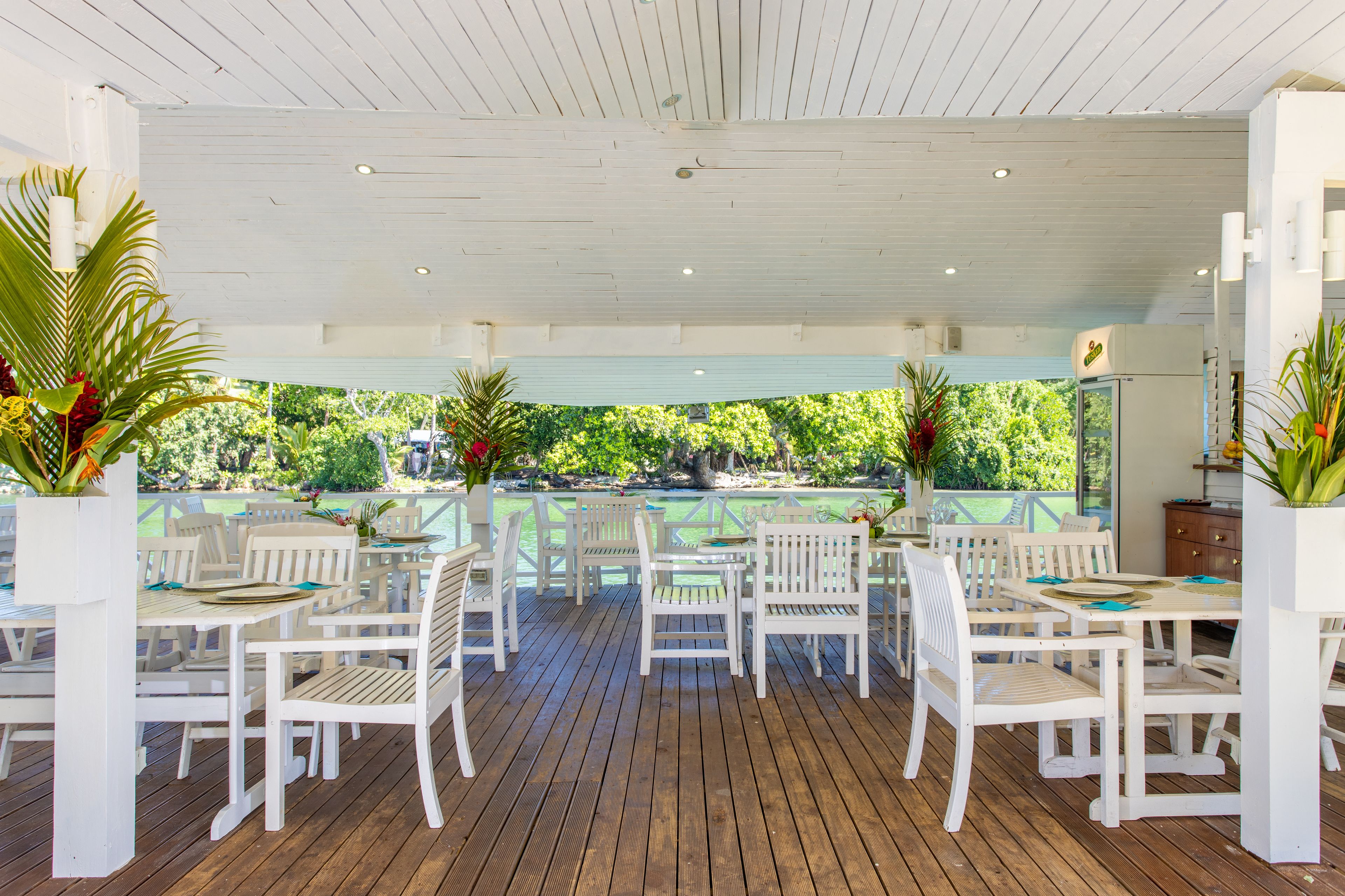 Un patio al aire libre con muebles de madera blanca y plantas en macetas.