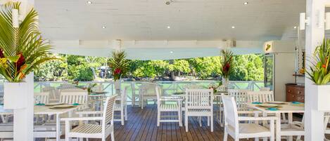 Un patio al aire libre con muebles de madera blanca y plantas en macetas.