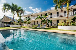 Una piscina al aire libre, tumbonas