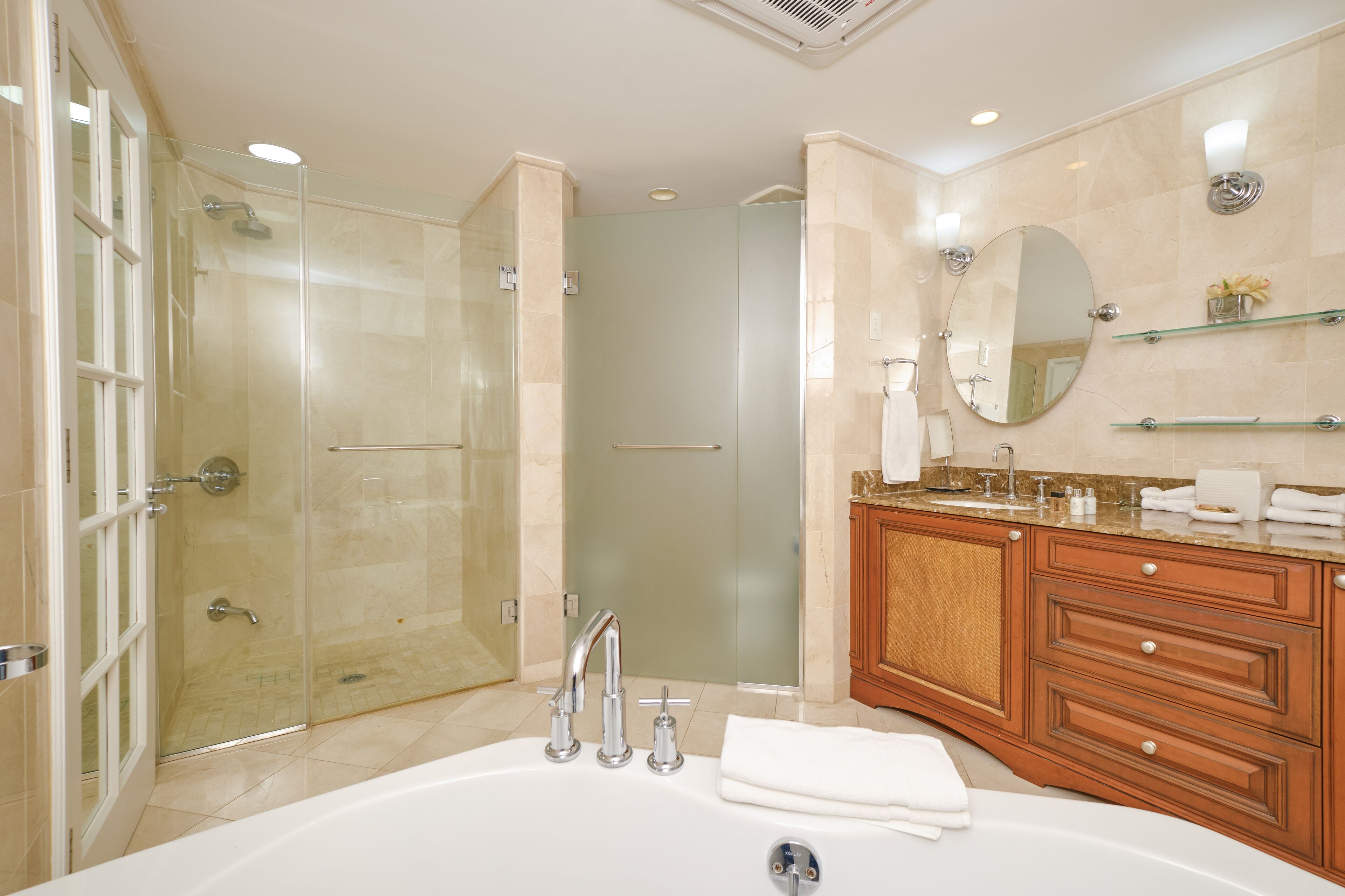 Une salle de bain moderne avec une douche à parois de verre, une baignoire sur pieds et des meubles en bois.