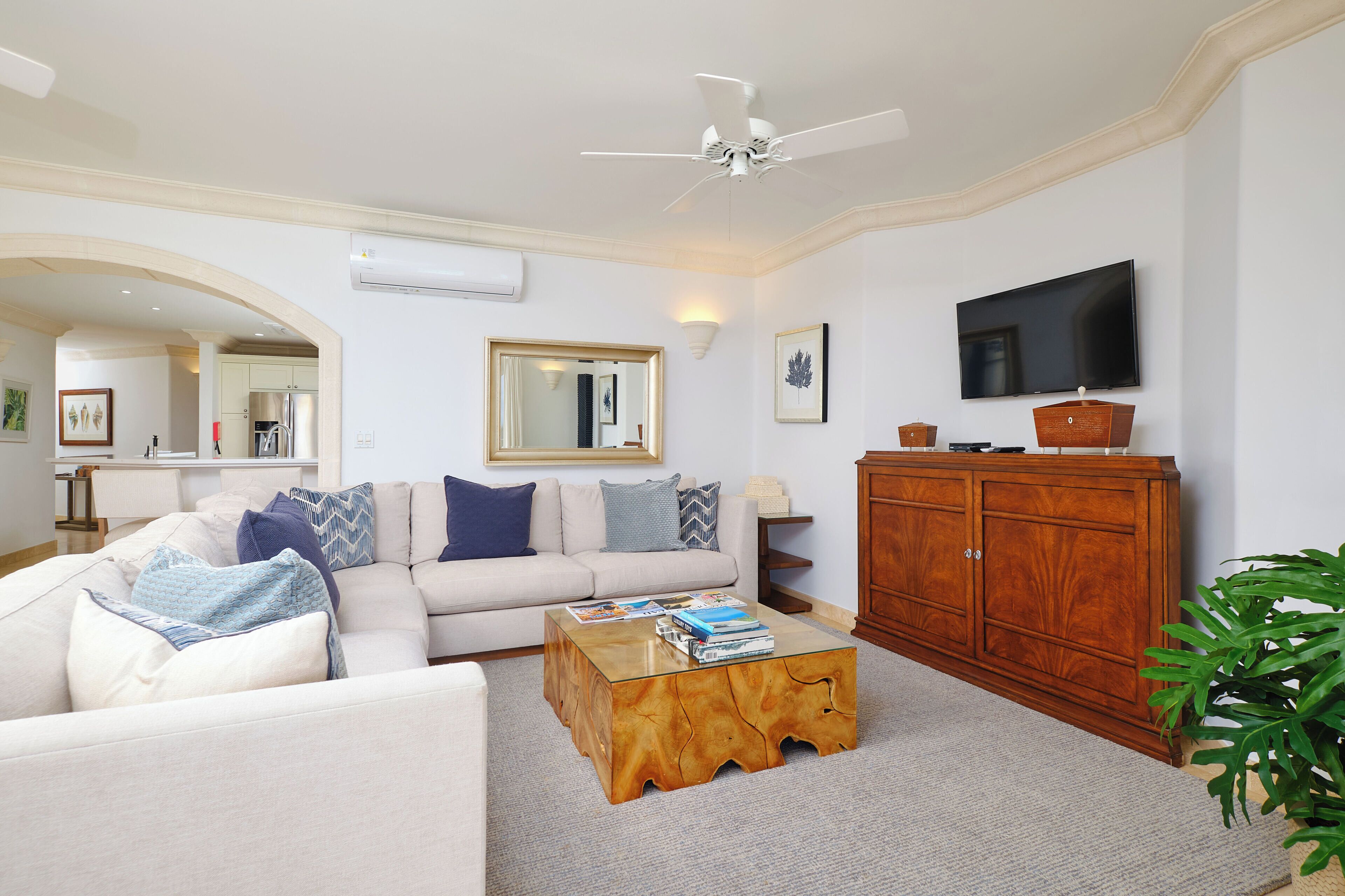 Una sala de estar con sofá, mesa de centro, televisor y un mueble de madera.