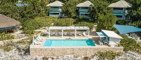 Alberca al aire libre, sombrillas en la alberca y camastros