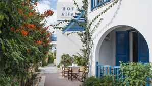 Un edificio blanco con una escalera azul y un cartel que dice 'HOTEL AITAN'.