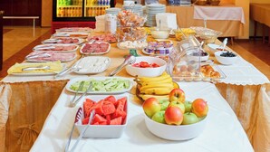 A buffet table with various food items and utensils. - Smolian (Nessebar)