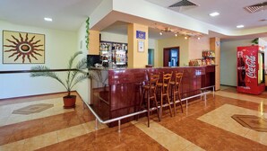 A hotel lobby with a reception desk, bar area, and seating. - Smolian (Nessebar)