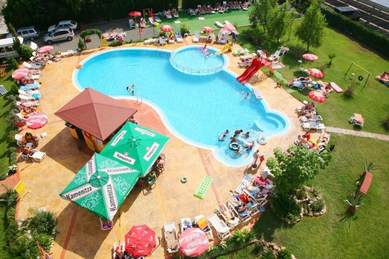 A swimming pool with multiple lanes, surrounded by lounge chairs and umbrellas.