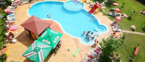 A swimming pool with multiple lanes, surrounded by lounge chairs and umbrellas.
