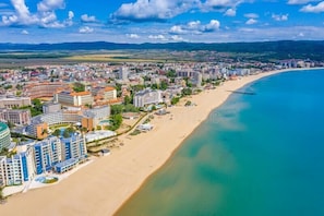 Overlooking a wide beach with clear waters, the city offers stunning coastal views.