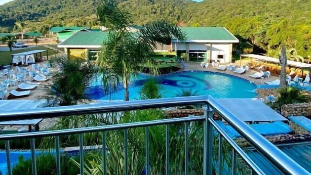 Un complexe hôtelier doté d’une piscine, de chaises longues et offrant une vue sur les montagnes.