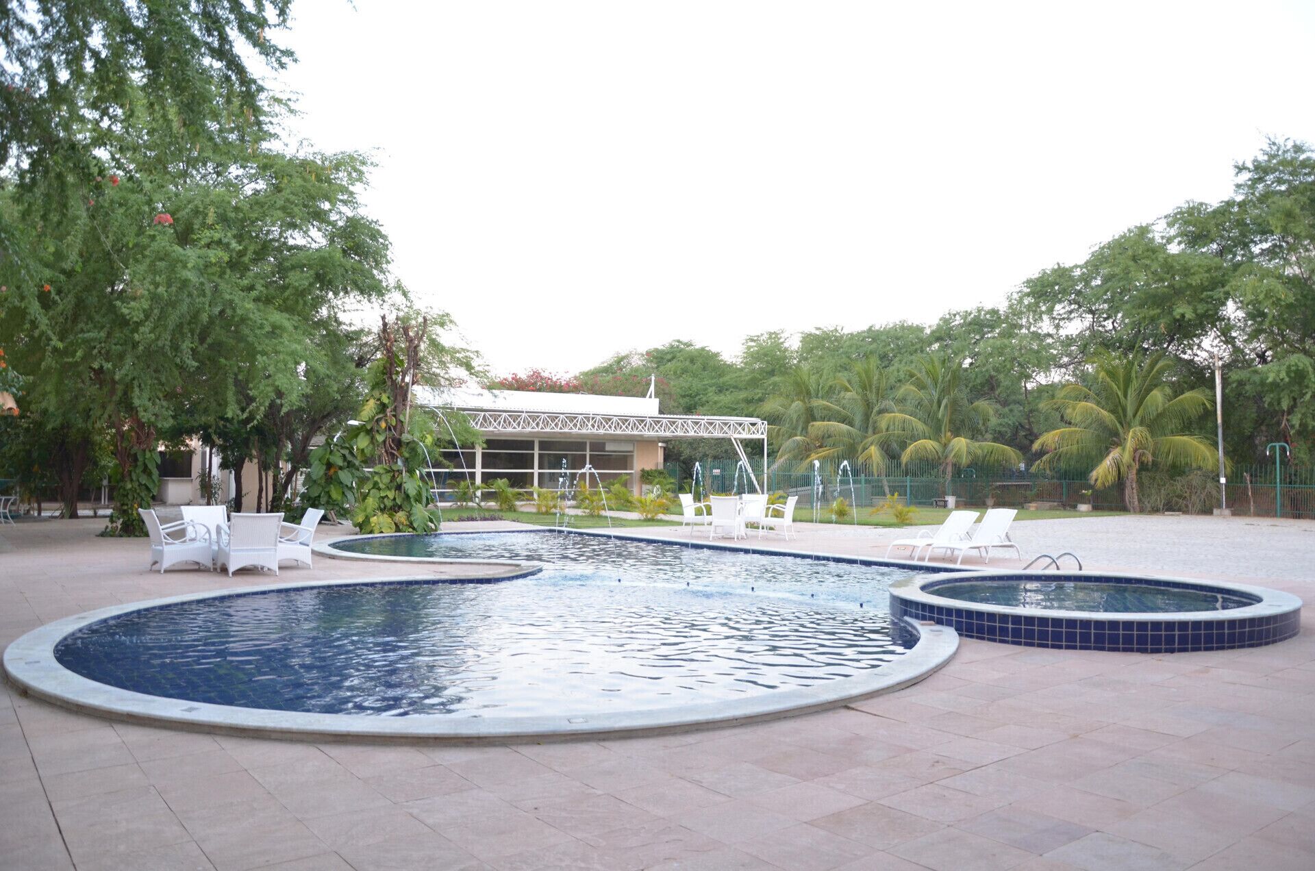 A swimming pool with lounge chairs and a covered seating area.