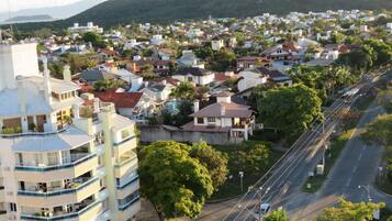 Ett bostadsområde med en blandning av en- och flerfamiljshus, en framträdande byggnad med en blå och vit fasad samt en väg med fordonstrafik.