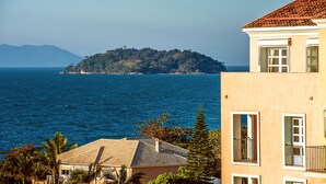 Un edificio costero con vista al mar y una isla distante.