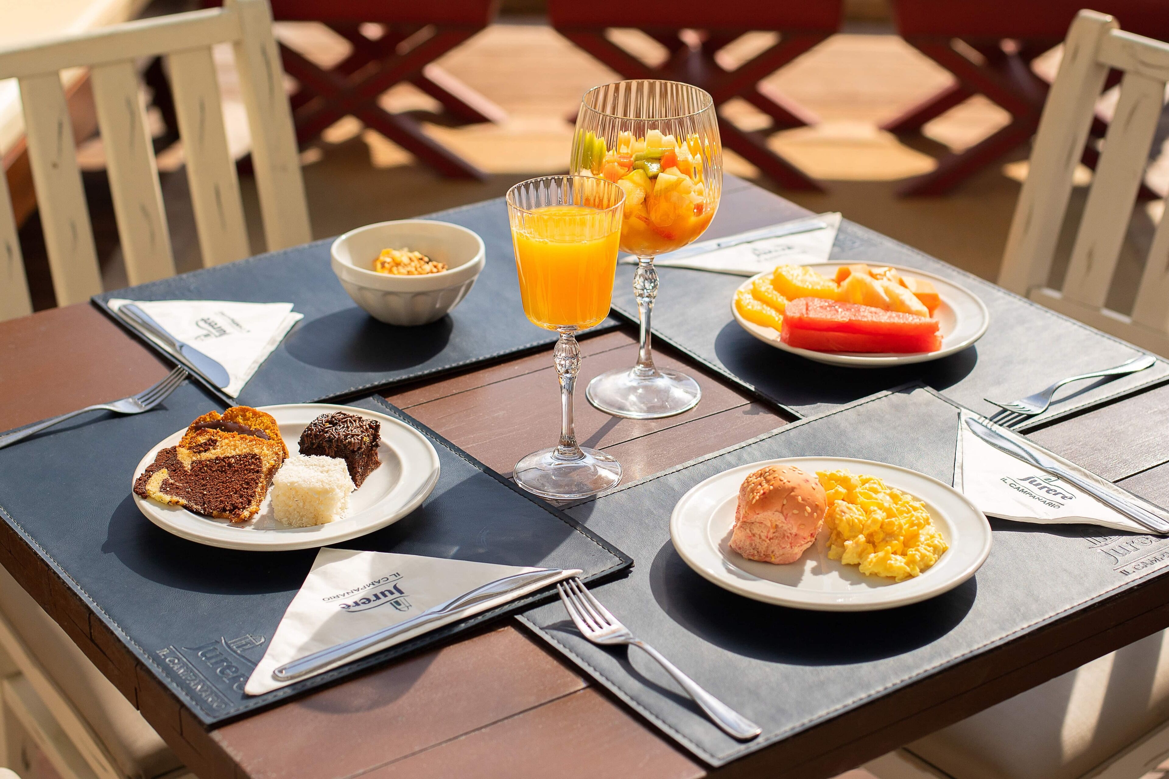 Una mesa dispuesta para el desayuno, con tostadas, huevos revueltos y fruta.