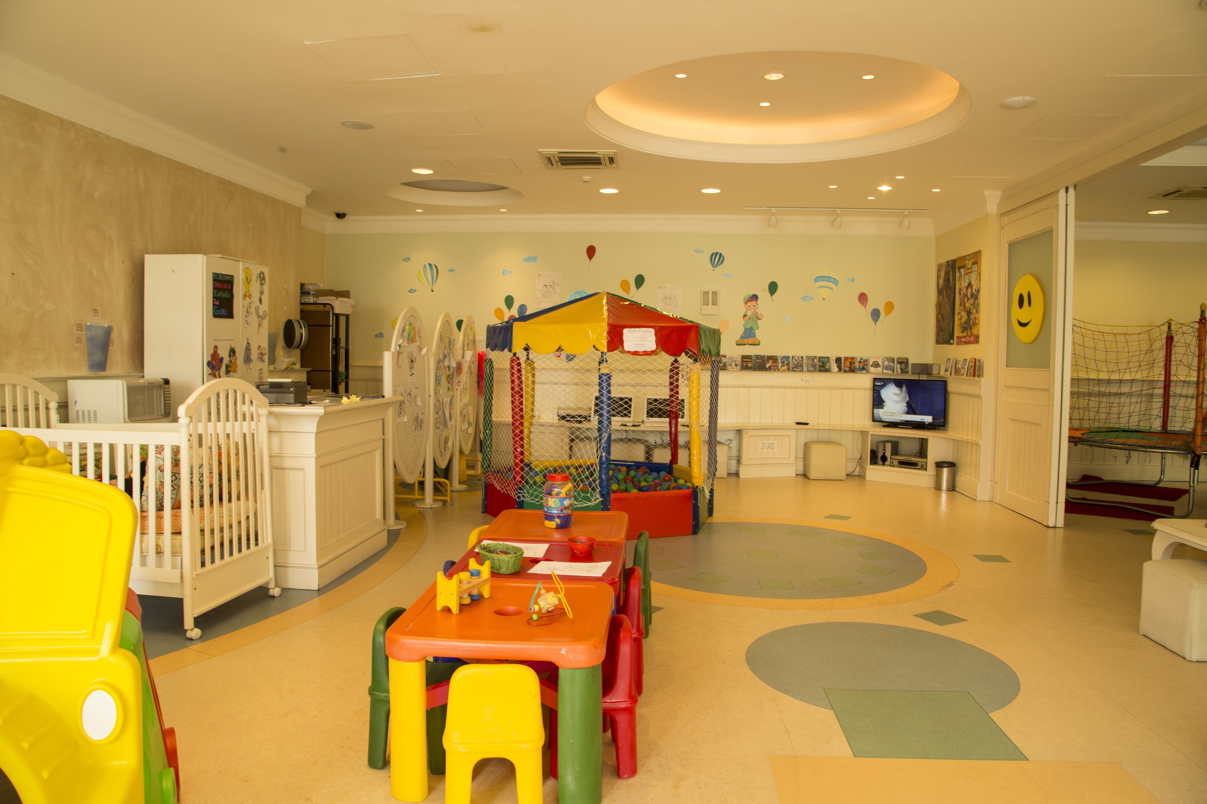 A children's play area with a play tent, a television, and a crib.