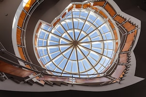 Una escalera de caracol con una cúpula de cristal que deja entrar la luz natural.