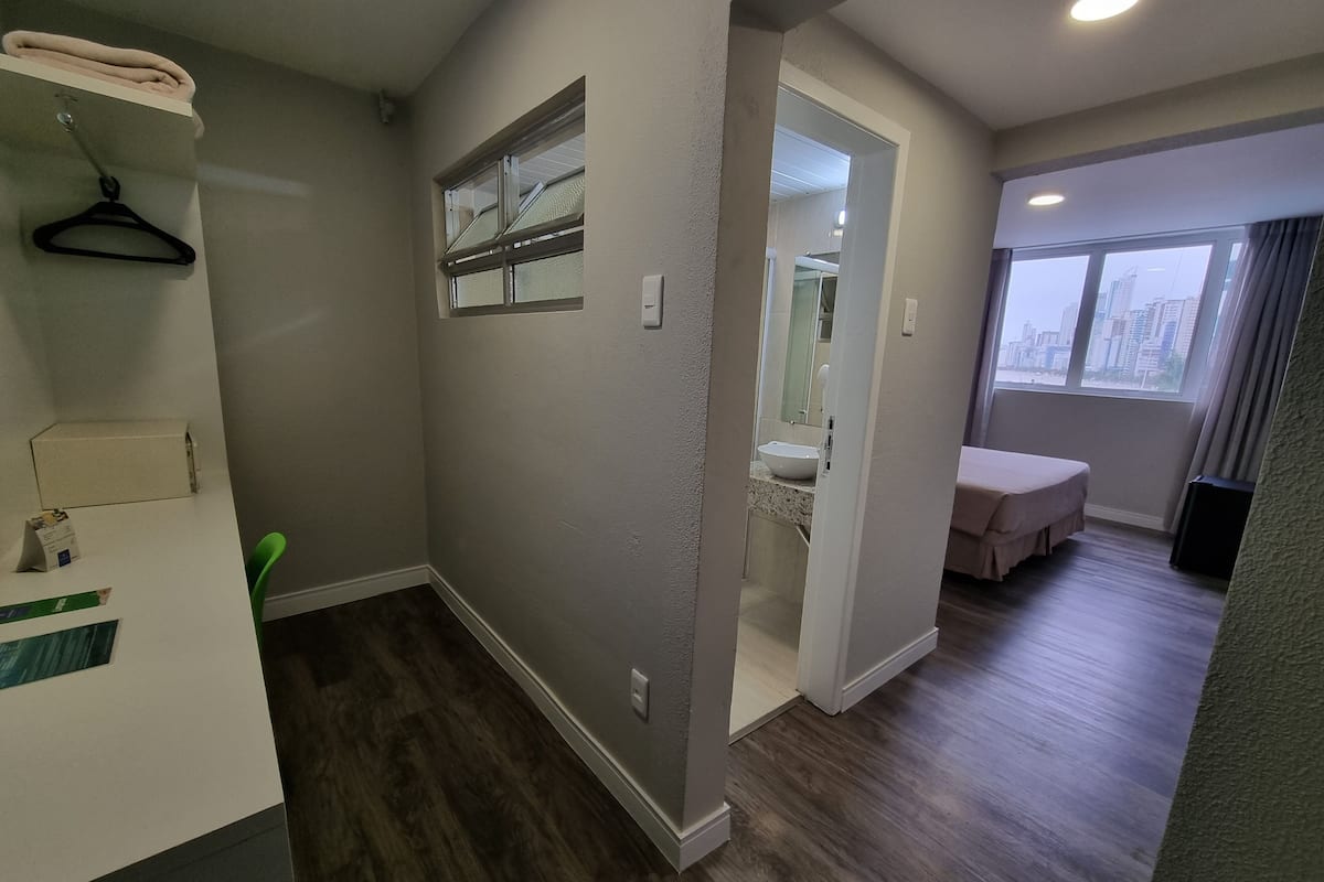 A modern bathroom with a sink, mirror, and towel rack.