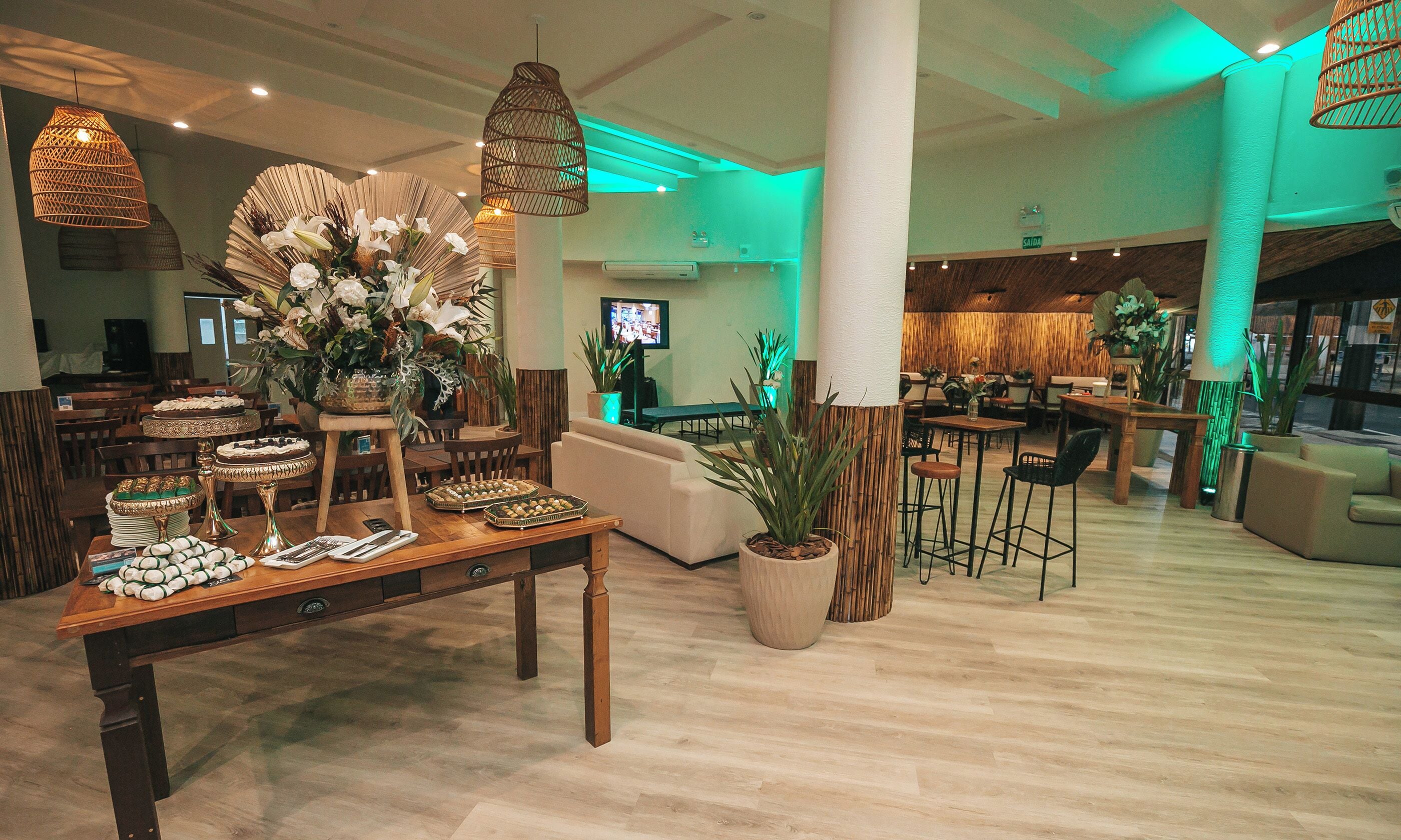 Un vestíbulo amplio con mostrador de recepción de madera, asientos cómodos y plantas decorativas.