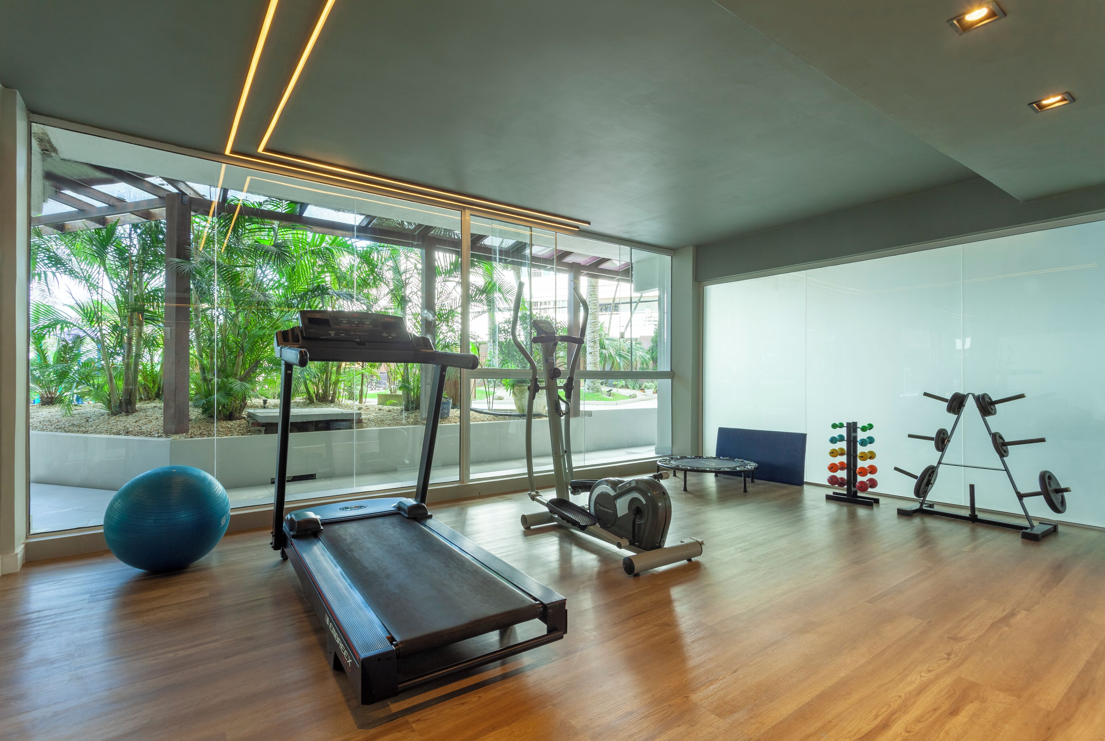 Uma academia moderna com esteira, bola de exercício e equipamentos de musculação.