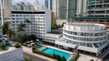 Un hotel moderno con piscina, rodeado de edificios altos.