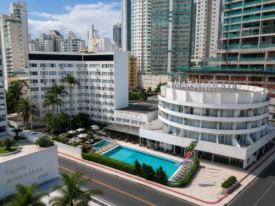 Un hotel moderno con piscina, rodeado de edificios altos.