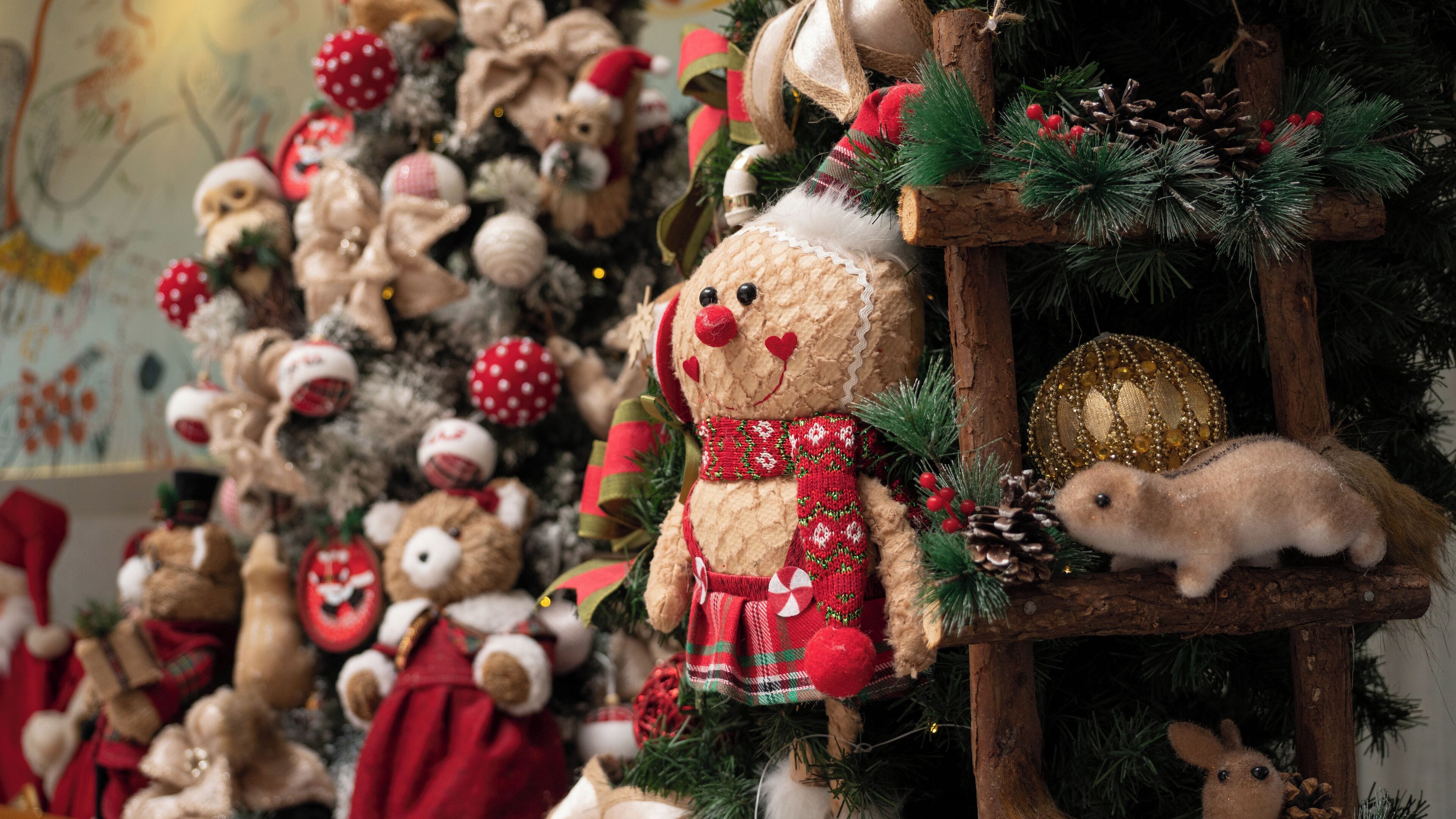 Uma árvore de Natal decorada com vários ursinhos de pelúcia e enfeites.