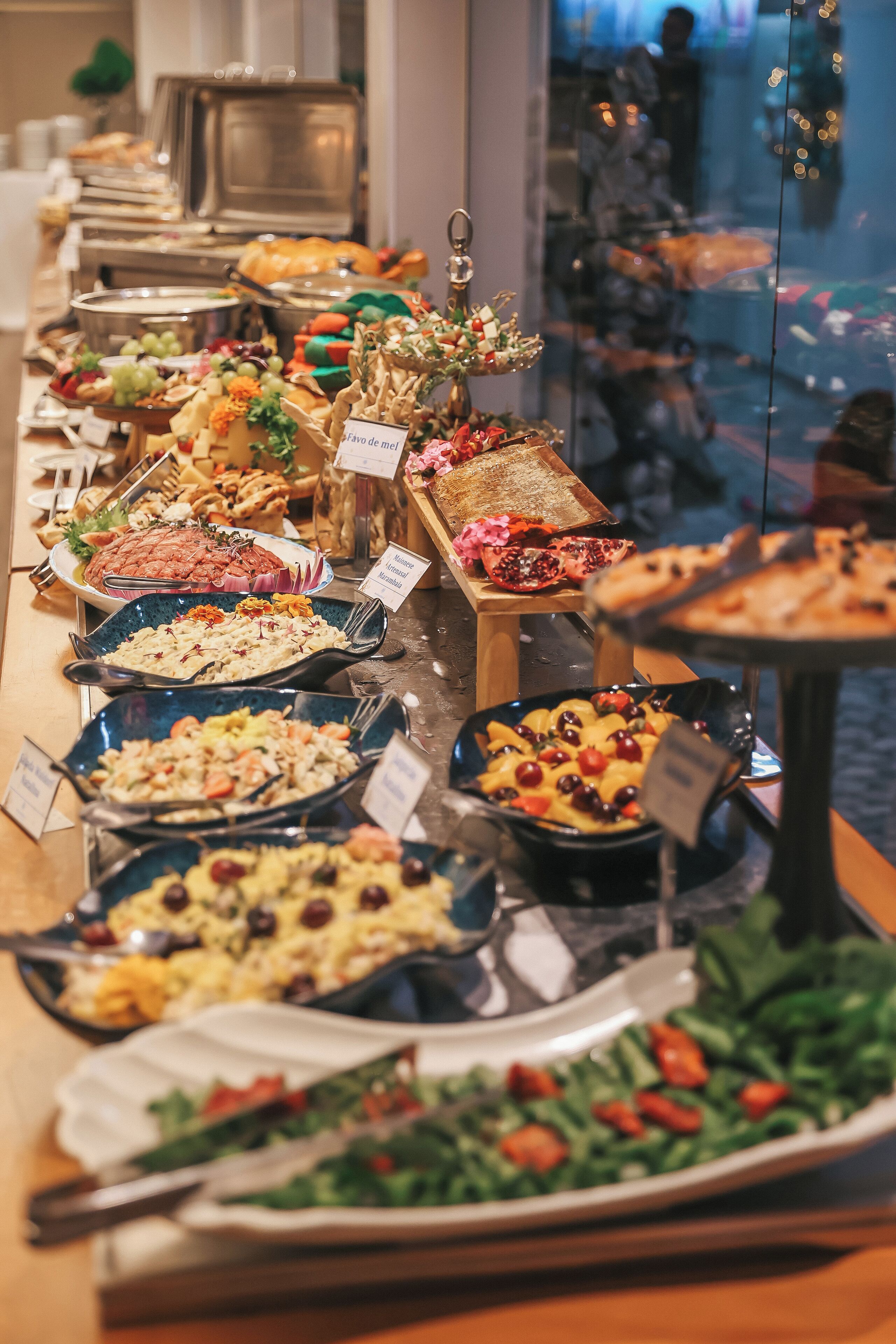 A buffet with various dishes and a pomegranate centerpiece.