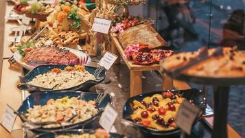 A buffet with various dishes and a pomegranate centerpiece.