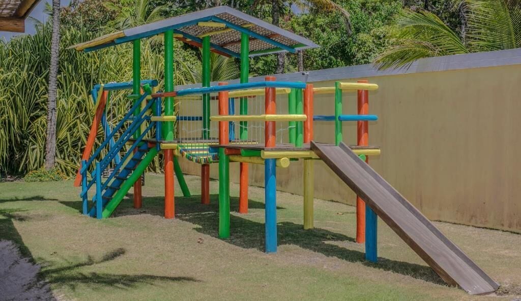 A playground with a slide, climbing structures, and a covered area.