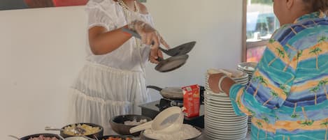 Un buffet proposant une variété de plats et une personne qui sert les aliments.