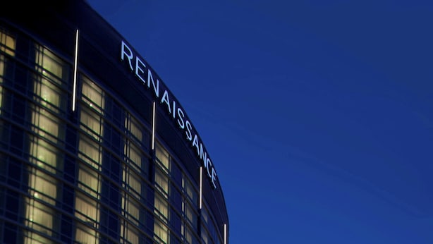 A modern hotel with a curved facade, large windows, and an American flag.
