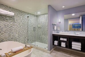A modern bathroom with a glass-enclosed shower, a freestanding bathtub, and a vanity with a mirror and sink. - Renaissance Arlington Capital View Hotel (Arlington)