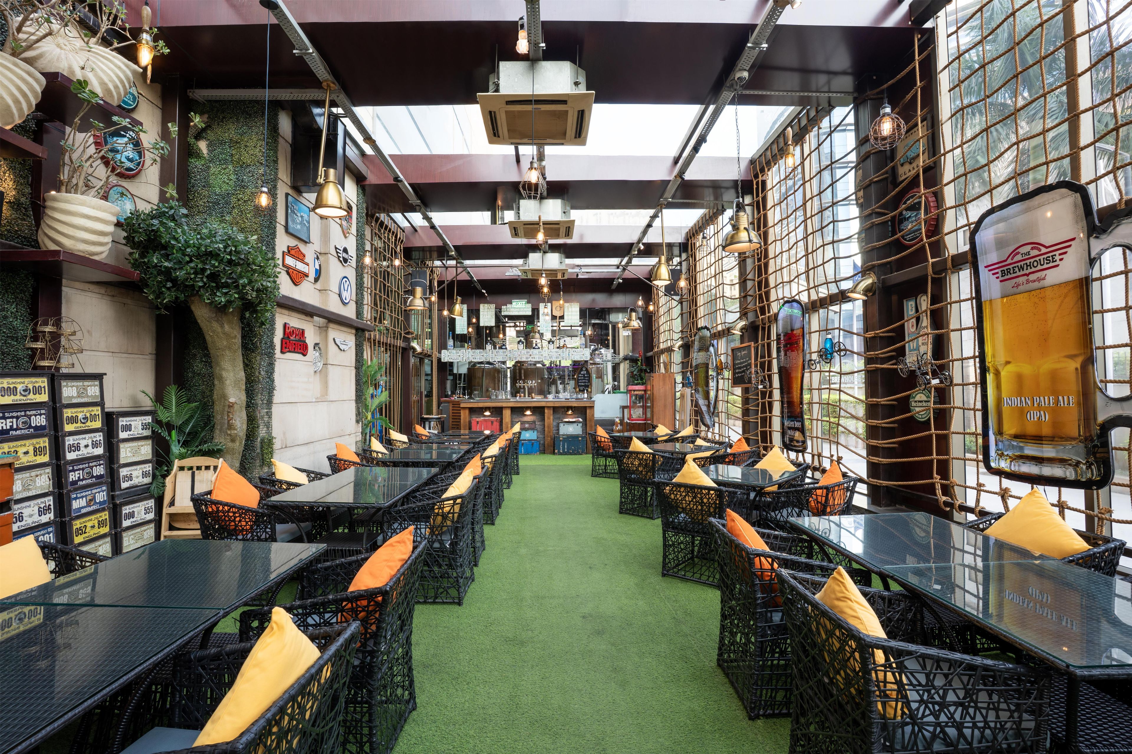 An indoor bar area with tables and chairs, a bar counter, and various wall decorations.