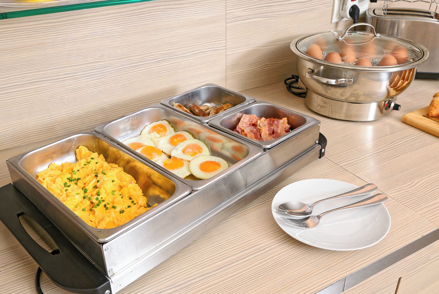 Ein Buffet mit Rührei, Spiegeleiern und Speck.