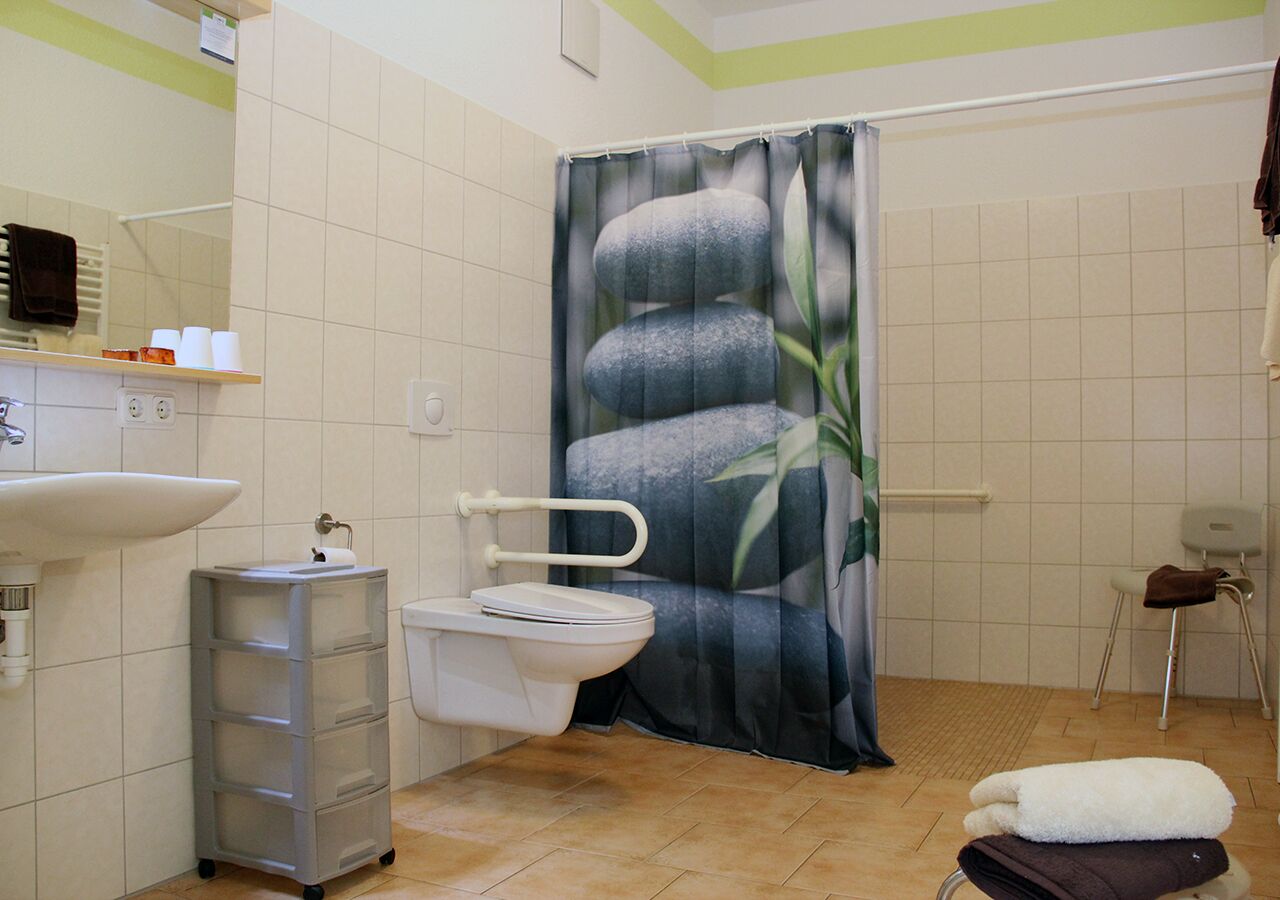 A bathroom with a toilet, sink, and a shower curtain with a stone pattern.