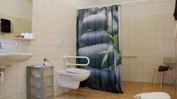 A bathroom with a toilet, sink, and a shower curtain with a stone pattern.