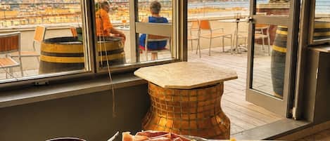 A dining area with a view of a cityscape through large windows.