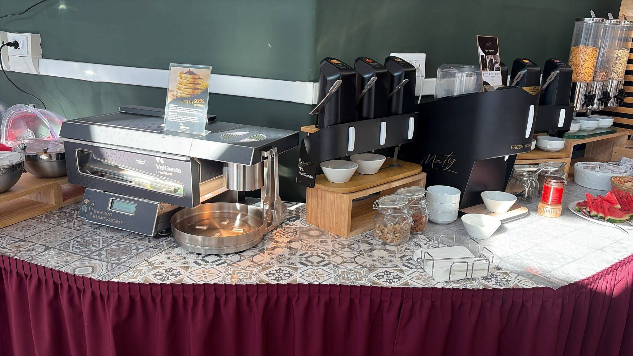 Un espace dédié au petit-déjeuner, équipé d’une machine à préparer les petits-déjeuners ValGarda, de machines à café et de différents récipients pour les aliments.
