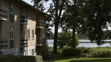 Un edificio de varios pisos con balcones que dan a un lago.