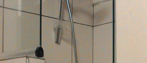 Une douche équipée d’un pommeau de douche à main et de commandes murales.