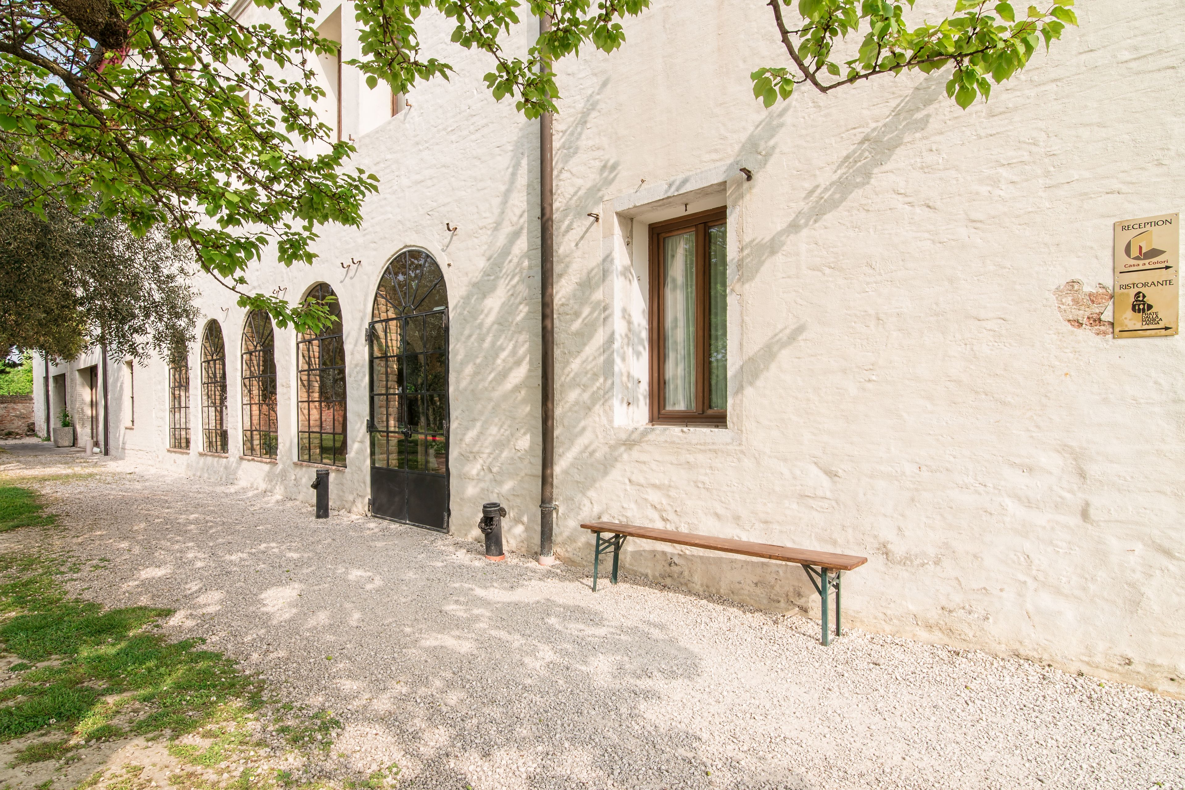 A building with arched windows, a reception sign, and a bench.