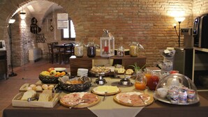 Een ontbijtbuffet met diverse etenswaren en een achtergrond van een bakstenen muur.