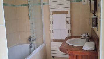 Un baño con bañera, ducha, lavabo y espejo.