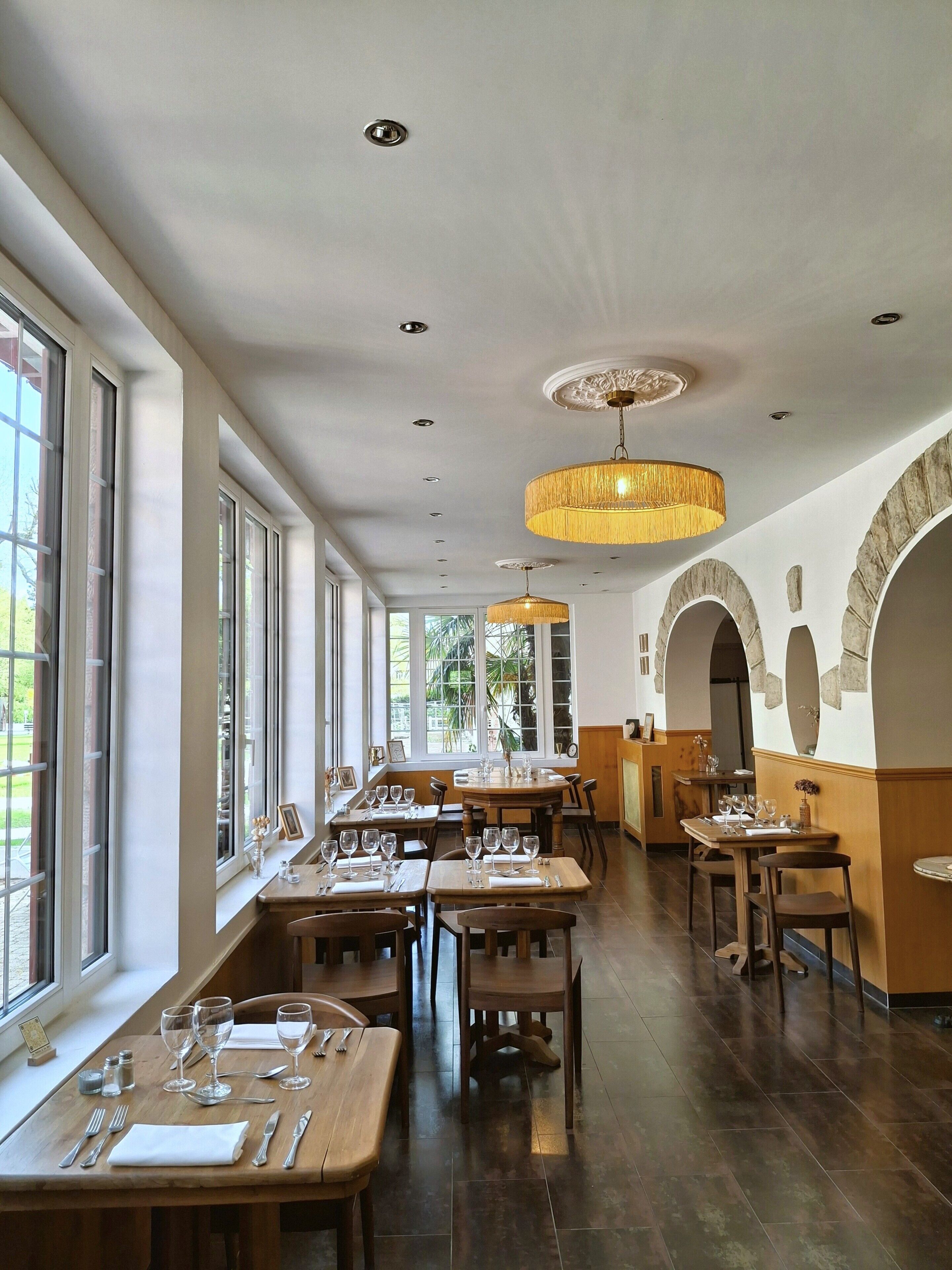 Un restaurant doté de nombreuses tables, de chaises et d’un grand lustre.