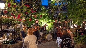 An outdoor music performance with a band playing in a garden setting. - Hotell Lindgården (Visby)