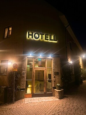 A hotel entrance with a sign reading "HOTELL" and a no parking sign. - Hotell Lindgården (Visby)